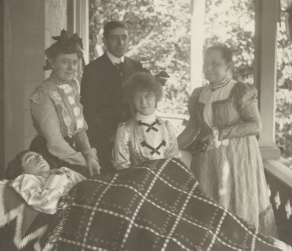 Will Adams with his parents Sidney and Harriet Adams, sister Bertha, and friend Norma Ross (seated) on the Adams Family Porch. (Photo Courtesy of the J.M. Longyear Research Library)